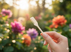Hand holding a small comb with a blurred floral background
