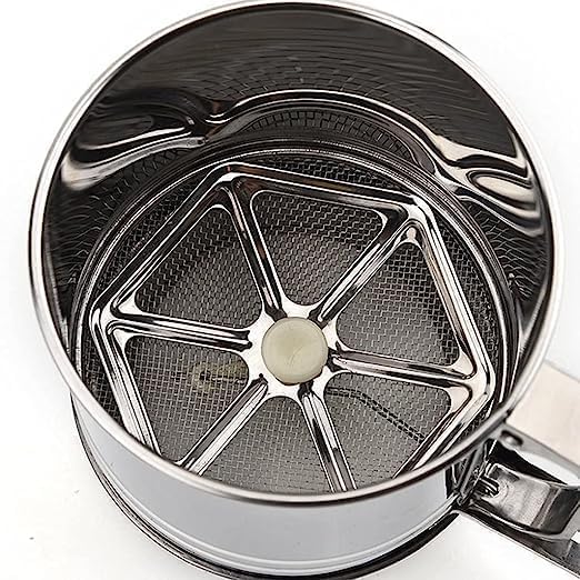Metallic tea infuser with a central ball on a white background