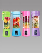Four colorful portable blenders with fruits inside on a gray background