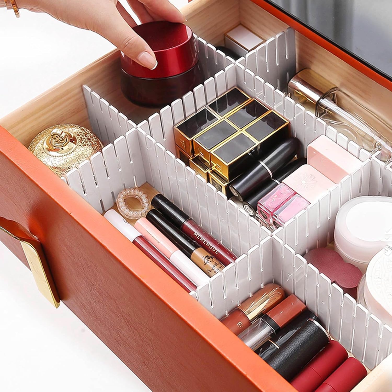 Makeup organizer with compartments filled with lipsticks and other cosmetic items.